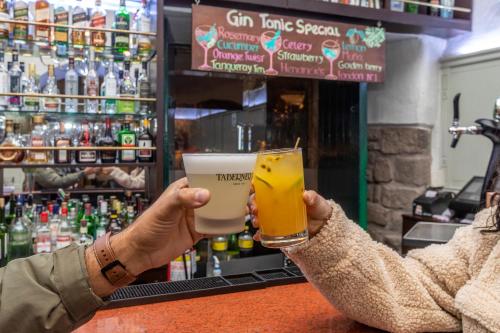 a person holding a glass of beer in a bar at Casa Andina Premium Cusco in Cusco