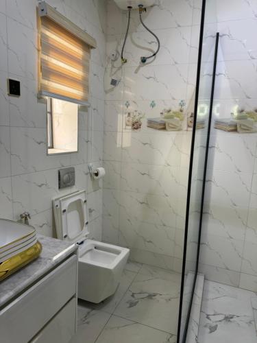 アブジャにあるJazeera Apartmentsの白いバスルーム(トイレ、シンク付)