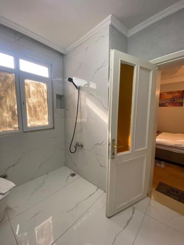 a bathroom with a shower with white marble walls at Berce Hotel Istanbul in Istanbul