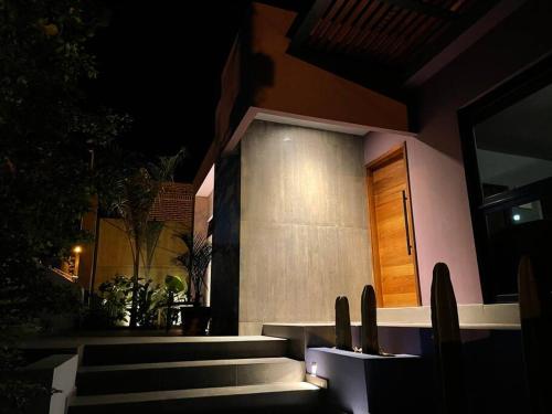 a house with stairs leading to a door at night at Casa Kamila en el centro de Todos Santos in Todos Santos