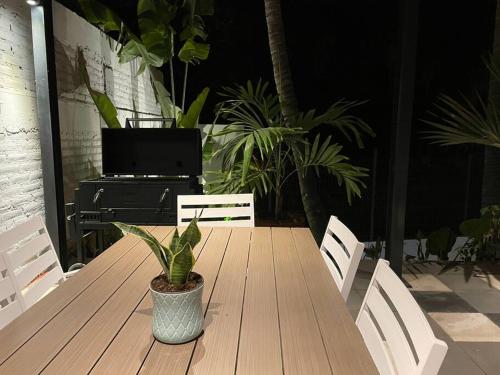 a wooden table with a potted plant on a patio at Casa Kamila en el centro de Todos Santos in Todos Santos