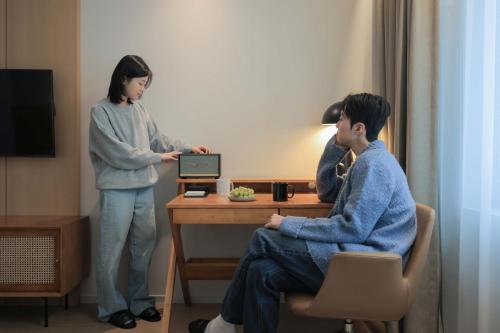 a woman and a man in a room with a laptop at Aank Hotel Incheon Guwol in Incheon