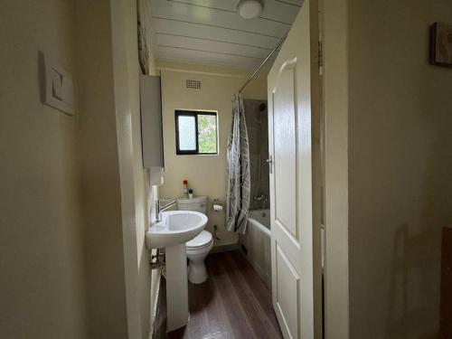 a small bathroom with a sink and a toilet at Cozy Kalundu Apartment in Lusaka