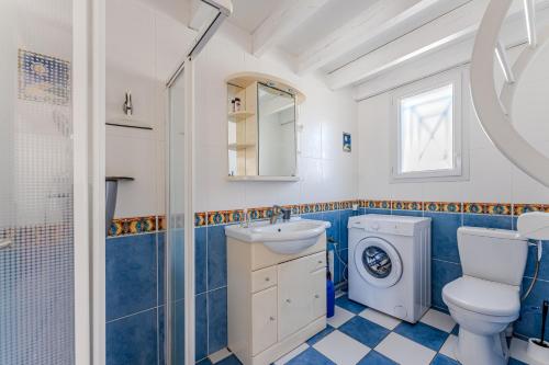 ein Badezimmer mit einem Waschbecken und einer Waschmaschine in der Unterkunft La plage, les lacs et le calme in Biscarrosse