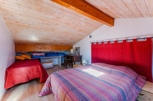 um quarto com uma cama vermelha e uma secretária em La plage, les lacs et le calme em Biscarrosse