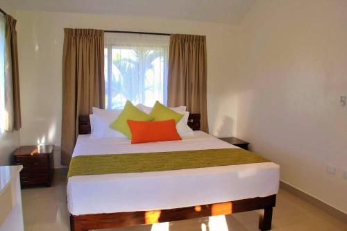a bedroom with a large bed with colorful pillows at Bula Villas in Nadi