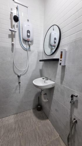 a bathroom with a sink and a mirror at Anzra Home2stay in Kertih