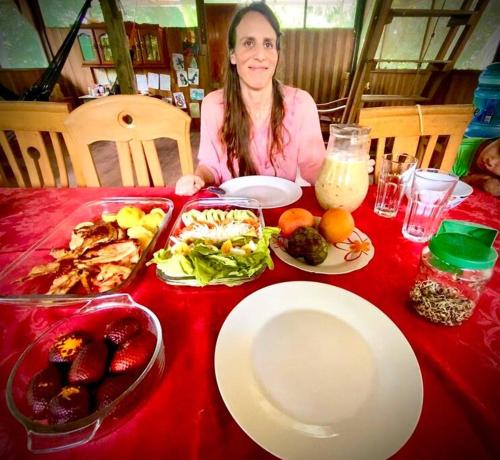 une femme assise à une table avec une assiette de nourriture dans l'établissement Jungle Lodge with lookout tower, à Pucallpa