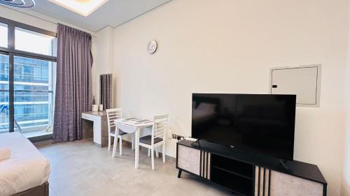 a living room with a large flat screen tv at Upscale Studio Apartment Burj View with Balcony Free Parking by Belvilla in Dubai