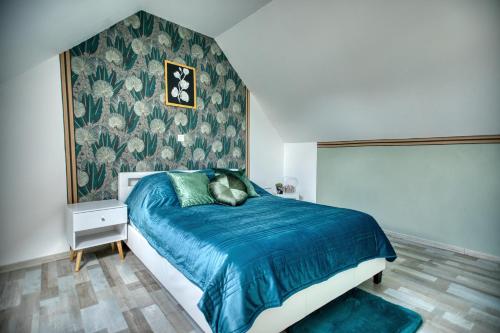 a bedroom with a bed with a blue comforter at charmante Maison de campagne 