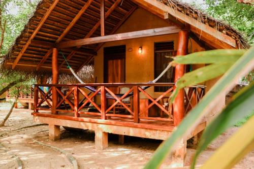 a house with a wooden porch in front of it at Ganesh Garden Beach Cabanas in Tangalle