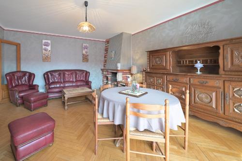 - un salon avec une table et des fauteuils en cuir dans l'établissement La Maison du Village, à Encausse-les-Thermes