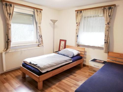 een slaapkamer met een bed en 2 ramen bij Schickes Apartment in Rottweil in Rottweil