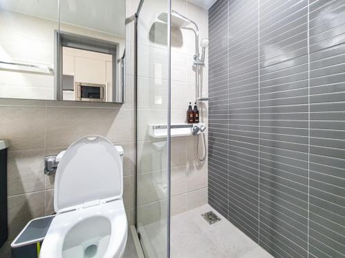 a bathroom with a toilet and a glass shower at Jeju Centerpoint N Residence in Jeju