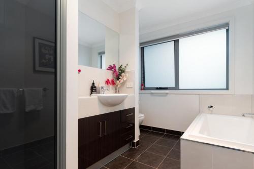 een badkamer met een wastafel, een toilet en een raam bij Comfortable Home 10 Minutes from Town - Wifi and Garage in Newnham