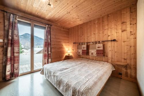 a bedroom with a bed and a large window at Sherpa - 10 pers in Saint-Jean-d'Aulps