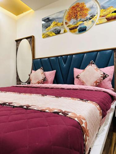 - une chambre avec un lit violet, des oreillers et un miroir dans l'établissement HOTEL E CLASSICO, à Bhavnagar