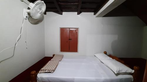 a small room with a bed with a red door at D Square Beach Home in Patna