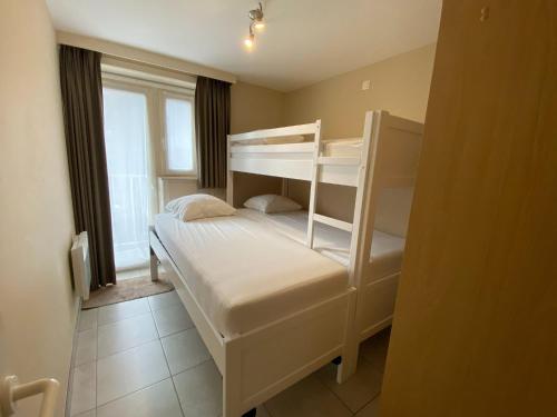 1 Schlafzimmer mit 2 Etagenbetten und einem Fenster in der Unterkunft Helios 0201 with central location in Nieuwpoort