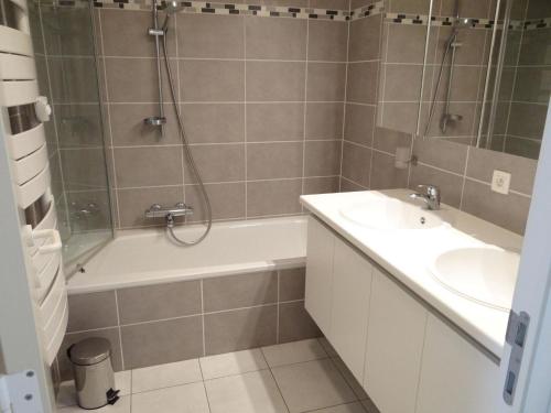 ein Bad mit einer Badewanne, einem Waschbecken und einer Dusche in der Unterkunft Helios 0201 with central location in Nieuwpoort