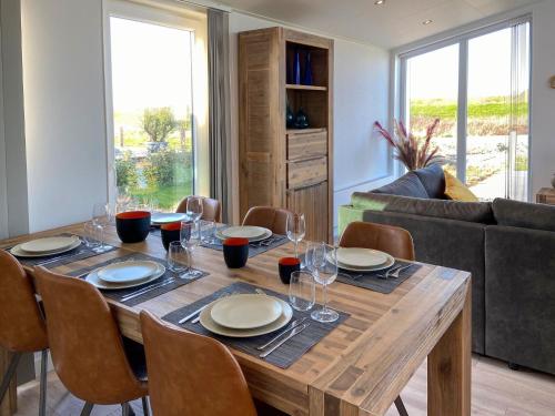 a dining room table with plates and wine glasses at Detached House in Zeeland with Scenic Terrace in Wemeldinge