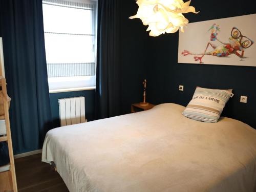 Schlafzimmer mit einem Bett und einem Kronleuchter in der Unterkunft Apartment in Nieuwpoort with balcony in Nieuwpoort