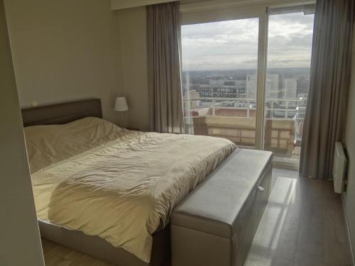 1 dormitorio con cama y ventana grande en Scorpio A 0901 with beautiful sea view, en Nieuwpoort