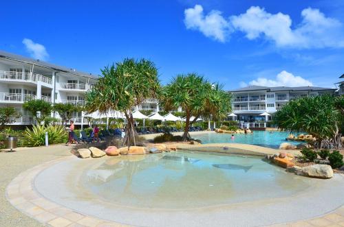 a pool at a resort with palm trees and buildings at Resort On The Beach 5118 with resort Pool in Kingscliff