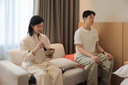 a man and a woman sitting in a room at Aank Hotel Incheon Guwol in Incheon