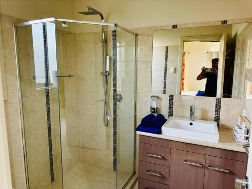 a person taking a picture of a bathroom with a shower at Morden Elegant 4 Bedroom House in Broadview