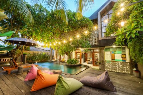 a house with a swimming pool with colorful pillows at Interconnection Hostel in Kuta