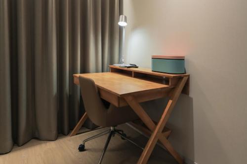 a wooden desk with a chair and a laptop on it at Aank Hotel Incheon Guwol in Incheon