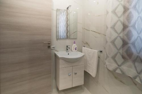 ein weißes Badezimmer mit einem Waschbecken und einem Spiegel in der Unterkunft Villa Marchese in Trecastagni