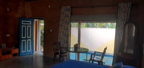 a living room with a glass table and a window at Hotel Dumaka in Gampaha