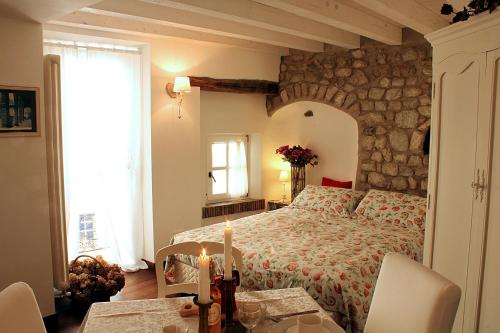 sypialnia z łóżkiem i kamienną ścianą w obiekcie Albergo Diffuso Polcenigo Ca' Bianca w mieście Polcenigo