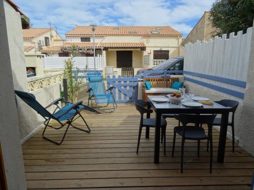 un patio avec des chaises et une table sur une terrasse dans l'établissement Maison près des plages, à Port-la-Nouvelle