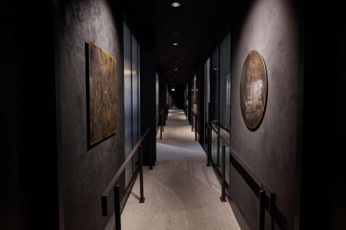 a hallway in a building with paintings on the walls at Abstract Hotel in Auckland