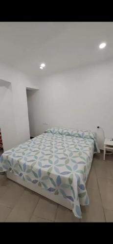 - un lit avec une couette bleue et blanche dans une chambre dans l'établissement Relax 1, à Playa de las Americas