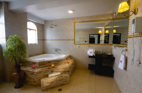 a bathroom with a large tub and a mirror at TerraMistica - Puno Centro in Puno