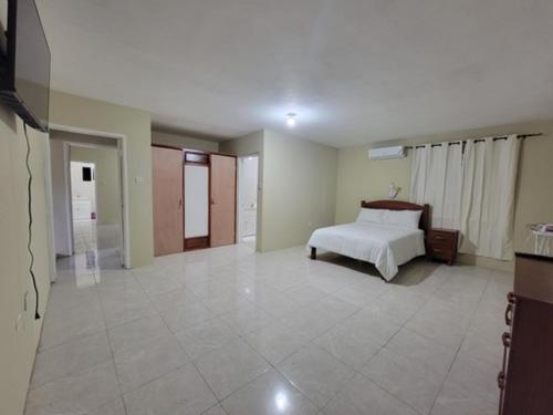 a bedroom with a bed and a tiled floor at Rudy suite in Montego Bay
