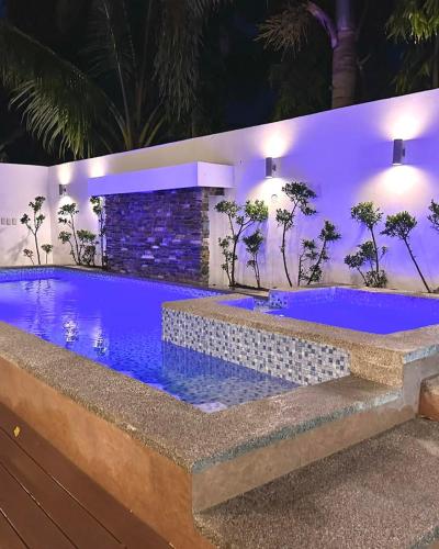 a swimming pool at night with blue lighting at The farmhouse villa beach resort in Morong