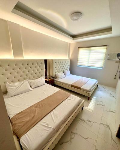 a bedroom with two beds and a window at The farmhouse villa beach resort in Morong