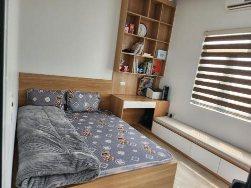 ein kleines Schlafzimmer mit einem Bett und einem Bücherregal in der Unterkunft TEELAD VILLA - MỘC CHÂU in Mộc Châu