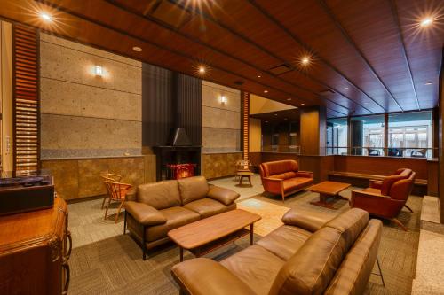 a living room with leather furniture and a fireplace at 別邸　たてしな薫風 in Yukawa
