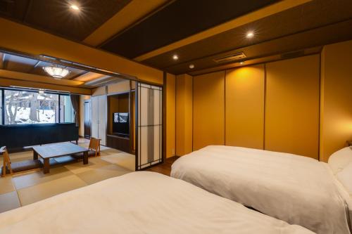two beds in a room with yellow walls at 別邸　たてしな薫風 in Yukawa
