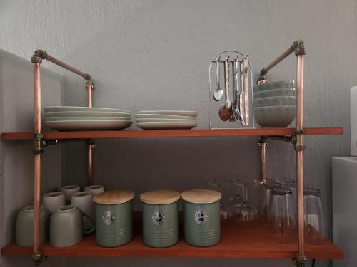 a shelf with plates and utensils on it at @241 Enkeldoorn Guesthouse in Pretoria