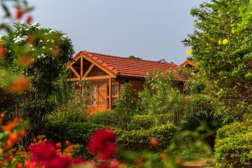 a wooden cabin in the middle of a garden at Leo wooden resorts in Hampi