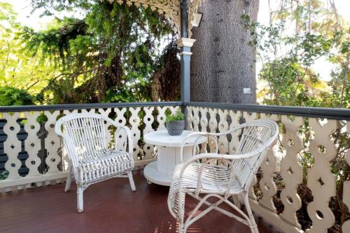 two chairs and a table on a porch with a tree at Charming On Charles in Launceston