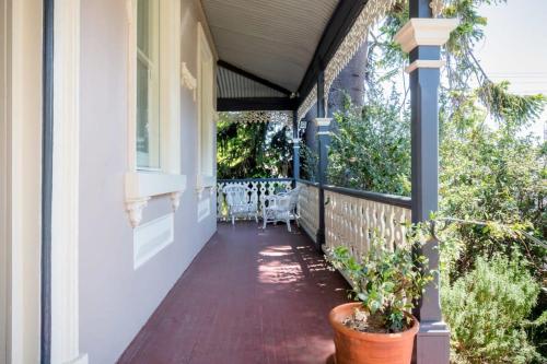 a porch of a house with a table and chairs at Charming On Charles in Launceston