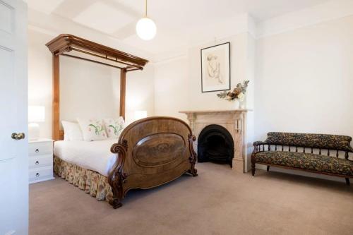 1 dormitorio con 1 cama grande y chimenea en Charming On Charles, en Launceston